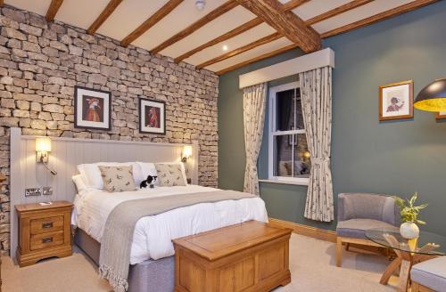 卡莱尔The Fleece at Ruleholme的一间卧室设有一张床和砖墙