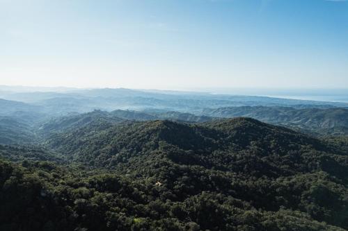 埃斯孔迪多港Pueblo del Sol Hotel Retreat的享有郁郁葱葱的绿色山脉的空中景致