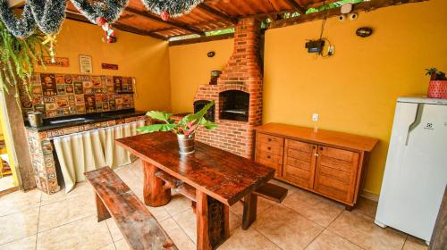 阿布拉奥Casa dos Franceses Ilha Grande的厨房配有木桌和壁炉。