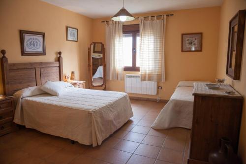 SotoserranoCasas Rurales Arroal的一间卧室设有两张床和窗户。