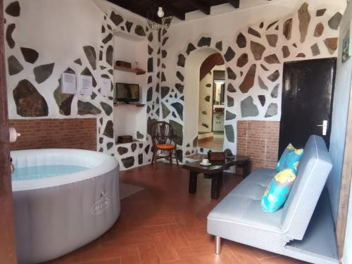 洛斯雷亚莱霍斯Casita Rural con Jacuzzi climatizado.的带浴缸和椅子的大浴室