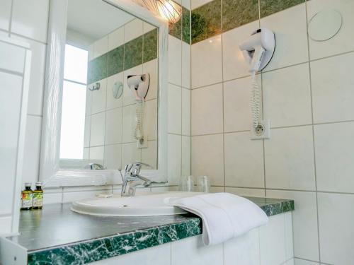 圣路易柏辽兹巴塞尔机场酒店的白色的浴室设有水槽和镜子