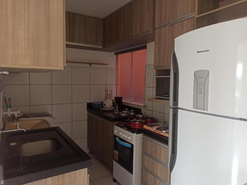因佩拉特里斯Apto dois quartos, cozinha equipada, portaria 24 h, área de lazer的厨房配有白色冰箱和炉灶。