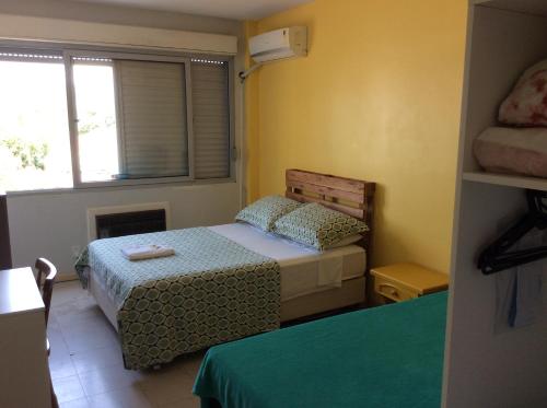 阿雷格里港Pousada Terra Sul的一间小卧室,配有两张床和窗户