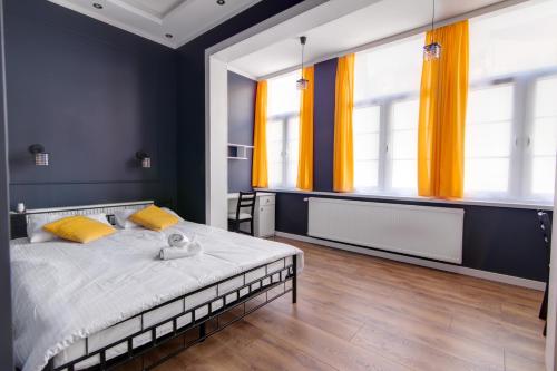 克雷尼察Rentimi - Apartament Kościuszki的一间卧室配有一张带黄色窗帘的大床