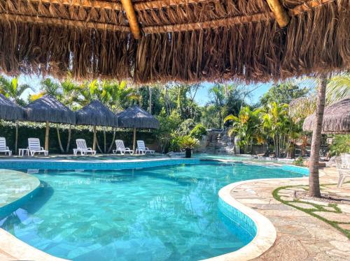 巴西利亚Villa Triacca Hotel Vinícola & Spa的度假村的游泳池,配有椅子和遮阳伞