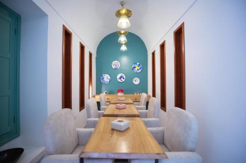 哈马马特Dar Hammamet Guest House & Hammam的一间会议室,配有木桌和椅子
