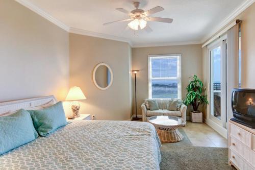 费南迪纳比奇Ocean Place II的一间卧室配有一张带吊扇的床和一台电视。