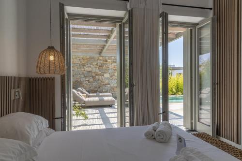 纳乌萨Cove Paros的一间卧室设有一张床和一个滑动玻璃门
