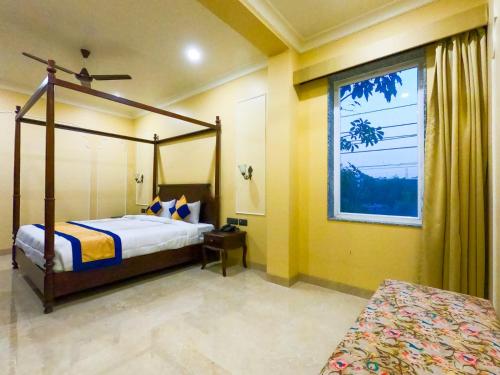 阿格拉The Taj Vista - Agra的一间卧室设有天蓬床和窗户。