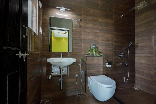 卡纳科纳Om Shanti Residence的一间带水槽、卫生间和镜子的浴室
