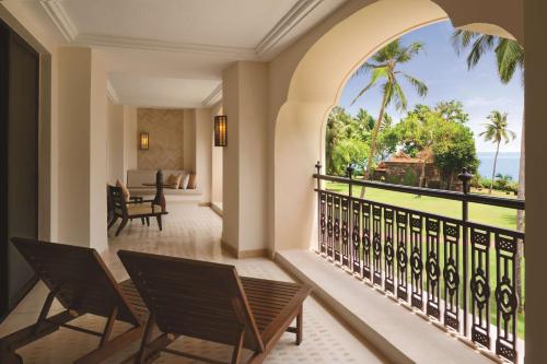 巴姆博利姆果阿君悦酒店的阳台配有椅子,享有海景。