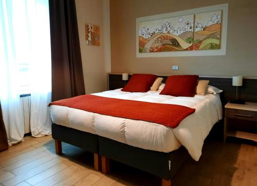 彼得拉桑塔Art Hotel Pietrasanta的一间卧室配有一张带红色枕头的大床