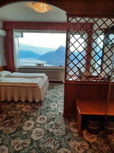 卢加诺科利布瑞酒店的一间卧室设有一张床和一个大窗户