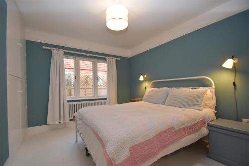 Rye HarbourSeaside Retreat的蓝色的卧室设有床和窗户