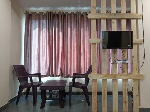 阿利鲍格Bliss Rooms的客厅配有桌椅和电视。