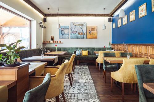 瑙吉考尼饶Hotel Vineyard Inn - Szőlőskert的餐厅设有长沙发和桌子,拥有蓝色的墙壁