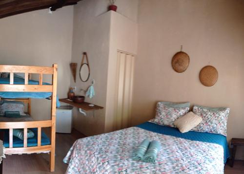 伊波兰加Canto do Sabiá PETAR Hospedagem Familiar的一间卧室配有一张床和一张双层床。