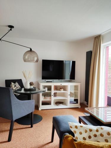 兰肯-格拉尼茨Appartement RügenZeit的客厅配有白色橱柜上的平面电视