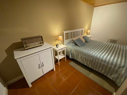 AchadaRibeira dos Caldeirões的一间卧室配有一张床和收音机