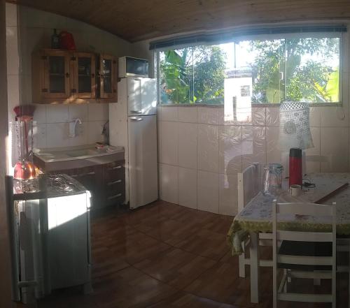 弗洛里亚诺波利斯Casa barreto的一间带桌子和冰箱的小厨房