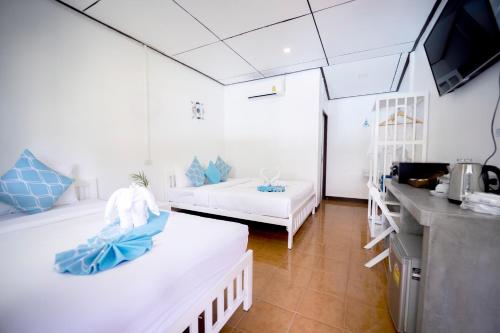 涛岛Assava Dive Resort - SHA Plus的一间设有两张床和一台电视的房间