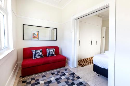 悉尼Chic Bondi Beach Pad的卧室内的红色椅子,配有床