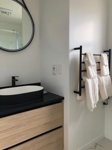 奥克兰Comfortable Holiday Home at Mt Wellington的一间带水槽和镜子的浴室
