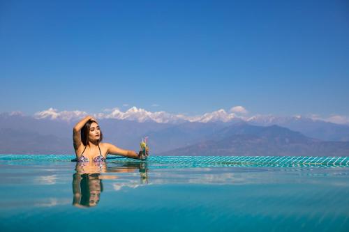 纳加阔特神秘山度假酒店的女人坐在水里喝着饮料