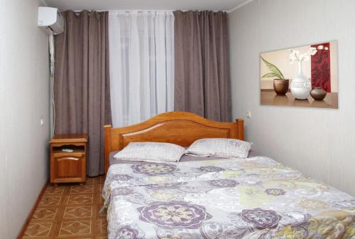 第聂伯罗Pobeda Apartment的一间卧室配有一张带木制床头板的床