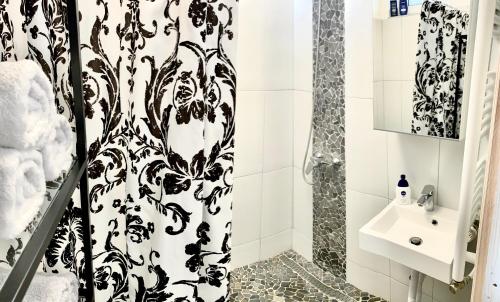 塞克萨德K1 Panoramic apartment的浴室设有黑色和白色的浴帘和水槽