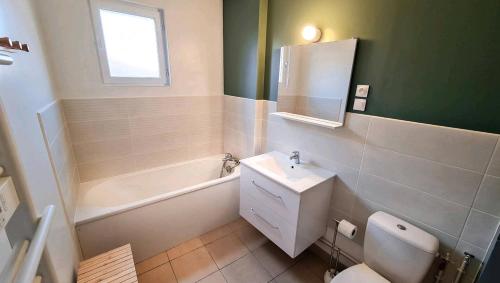 CarvinGîte Saint Martin的浴室配有盥洗盆、卫生间和浴缸。
