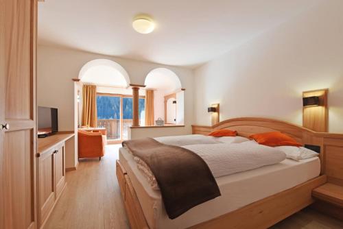 奥蒂塞伊Hotel Brunello的一间卧室配有一张大床和电视