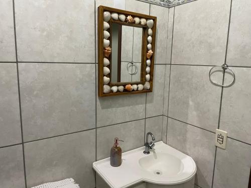 普腊亚罗萨Pousada Elementais do Rosa的一间带水槽和镜子的浴室