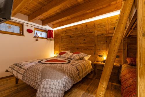 摩德纳迪-坎皮格里奥Nido del Brenta的卧室配有一张床铺,位于带木墙的房间内