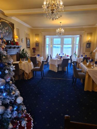 AuchencairnBalcary Bay Country House Hotel的用餐室配有桌子和圣诞树