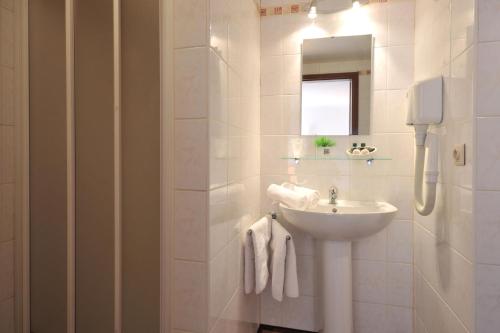 特镇佩龙酒店的白色的浴室设有水槽和镜子