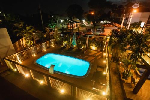 普腊亚罗萨Pousada Cacau的夜间室外游泳池