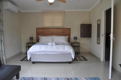 ManguziKosi Khaya的卧室配有一张白色大床,上面有弓