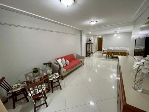 伊列乌斯3 SUITES Vista Mar - WI-FI, PISCINA, SAUNA, ACADEMIA, GARAGEM 2 CARROS的客厅配有沙发和桌子