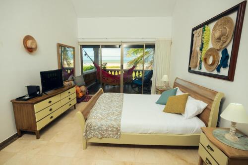 里奥阿查GUAJIRA CASA DEL MAR的一间卧室配有一张床、一台电视和一个阳台