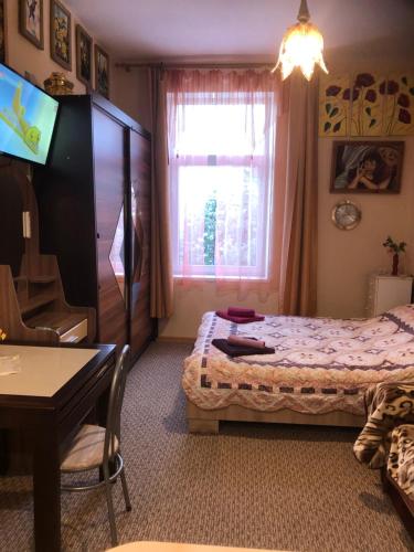 克拉斯拉瓦Krāslava City Apartment的一间卧室配有一张床、一张桌子和一个窗户。