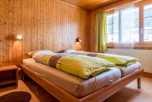 菲施Chalet Sunnegga的卧室配有木墙内的一张床
