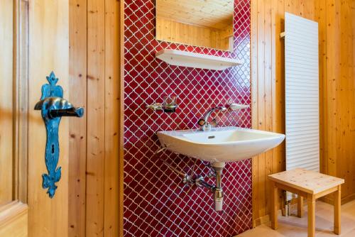 菲施Chalet Sunnegga的一间带水槽和红色瓷砖墙的浴室