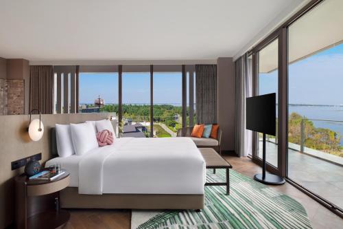 苏州苏州阳澄半岛英迪格酒店的卧室设有一张白色大床和大窗户
