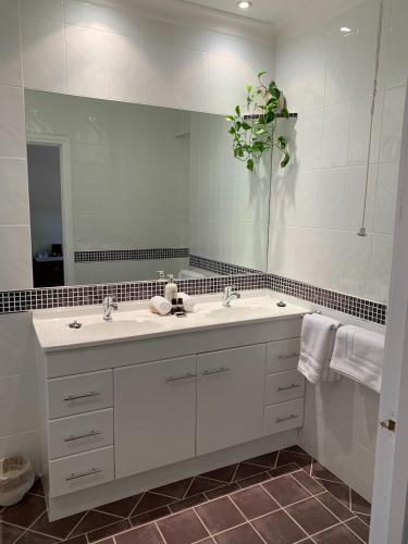 约克Avon Terrace Guest House的一间带两个盥洗盆和大镜子的浴室