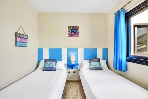 科蒂略Casa Puerto del Tostón的蓝色和白色条纹间内的两张床