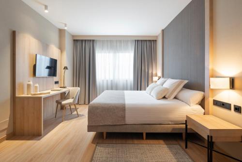 巴斯提安吉洛加勒拉斯阿提卡21号酒店的酒店客房配有一张床、一张书桌和一台电视。