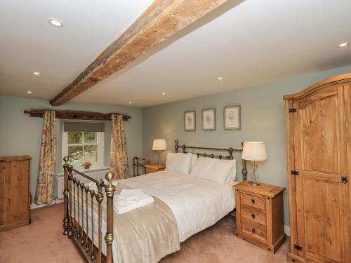 彭里斯Rose Cottage的一间卧室配有一张大床和一个木制橱柜