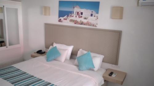 萨伊迪耶Hotel Atlal的一间卧室配有一张带蓝色和白色枕头的床